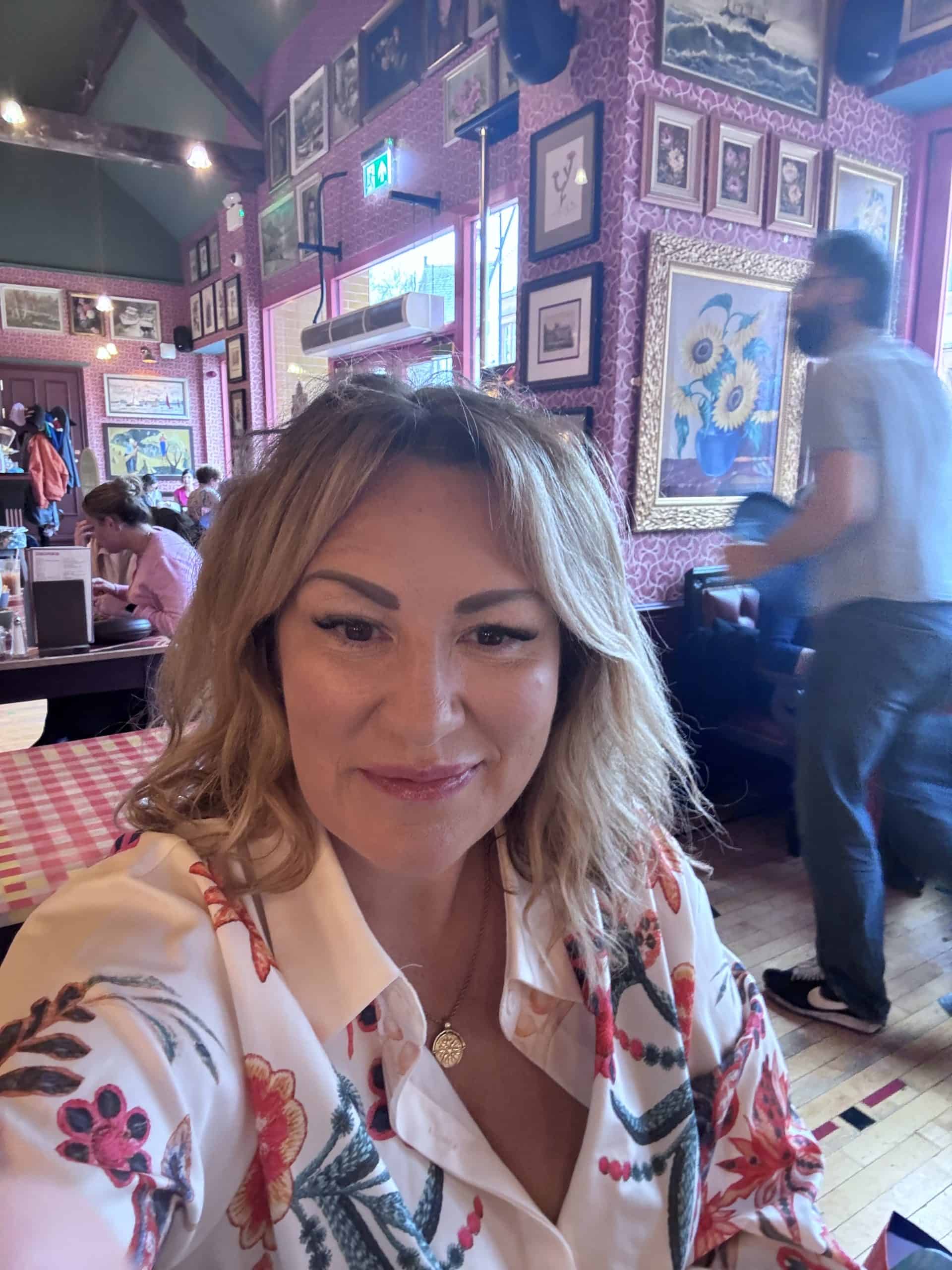 Niki Saunders-Fearns sitting calmly in a café, smiling